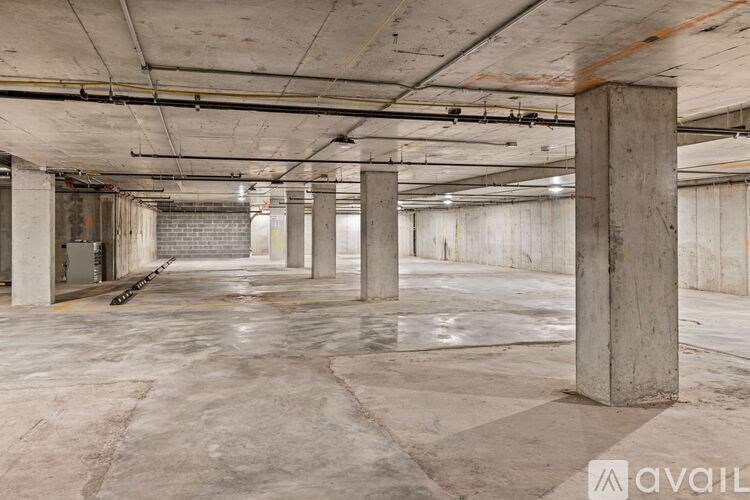 A large, empty parking garage with concrete pillars and floors.