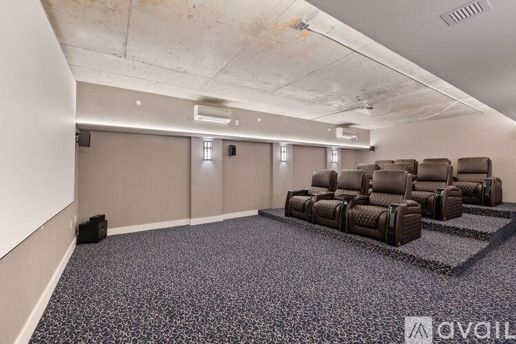 A room with a carpeted floor and a row of brown chairs.