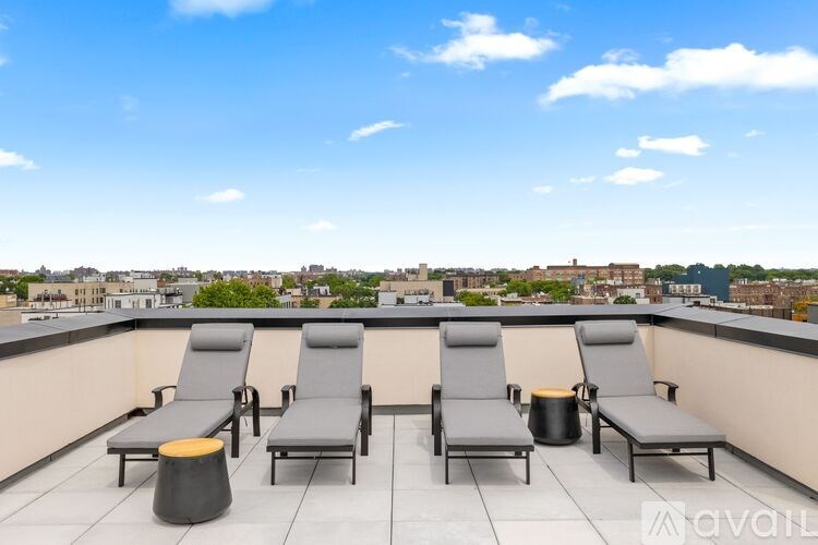 A patio with four chairs and a table is overlooking a cityscape.