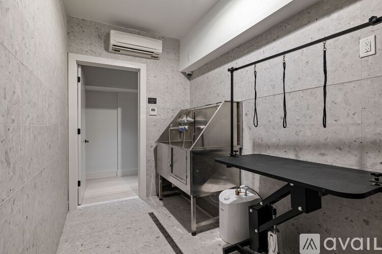 A kitchen area with a stainless steel sink and a black countertop.