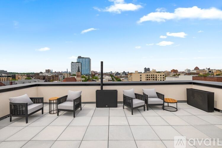 A balcony with furniture and a cityscape in the background.