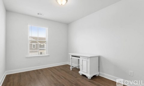 A room with a window and a white cabinet.