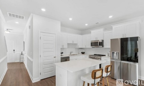 A modern kitchen with white cabinets and stainless steel appliances.