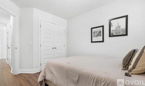 A bedroom with a bed, two pictures on the wall, and a door.