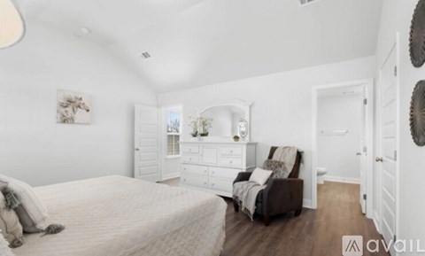 A bedroom with a large bed and a chair.