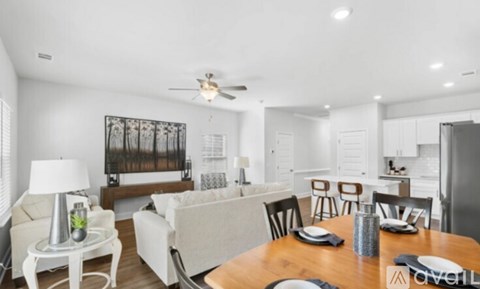 A modern dining room with a wooden table set for four.