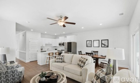 A living room with a white couch and a ceiling fan.