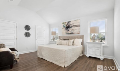 A bedroom with a large bed and a wooden floor.