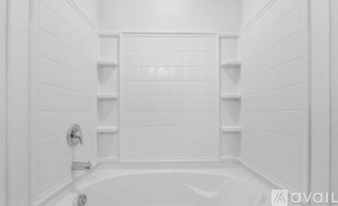 A white bathroom with a tub and shelves.