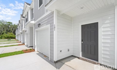 A row of white houses with grey doors.