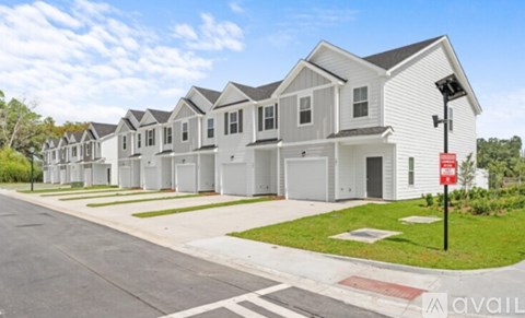 A row of houses with a red and white sign on a pole.