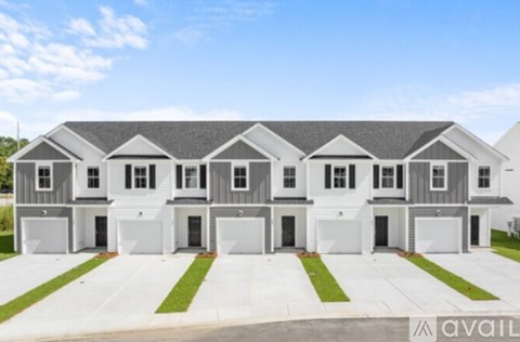 A row of identical houses with garages in front.