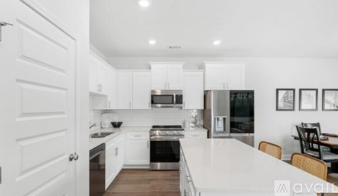 A modern kitchen with white cabinets and appliances.