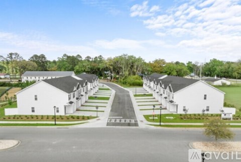 A row of white houses are lined up on a street.