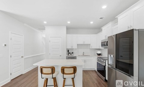A modern kitchen with white cabinets and a center island.