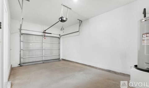 A garage with a white wall and a closed white door.