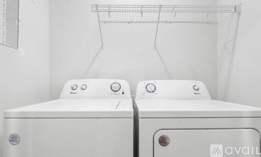 Two white washing machines are in a laundry room.