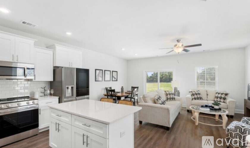 A modern kitchen with white cabinets and a black stove top oven.