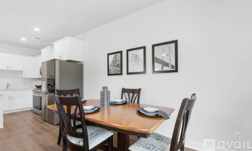 A dining area with a table set for two and chairs around it.