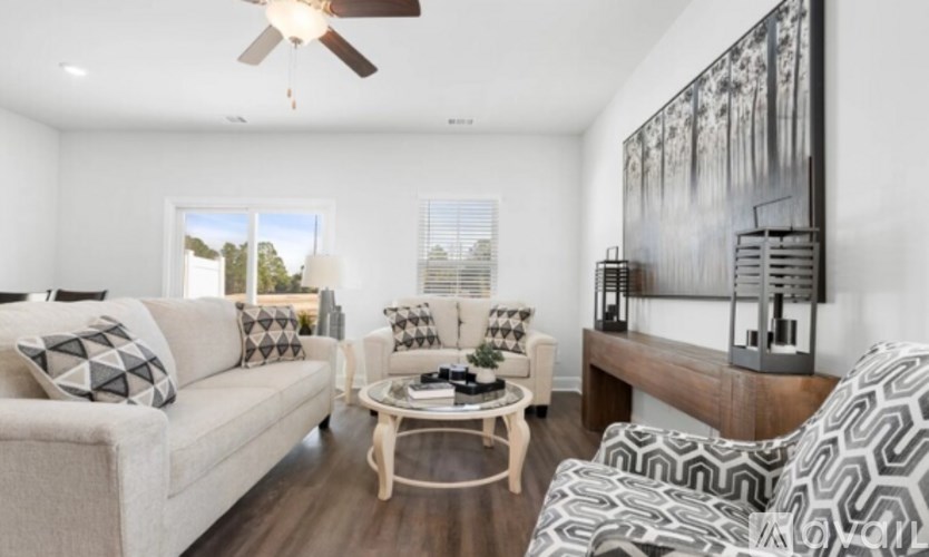 A living room with a white couch, a coffee table, and a painting on the wall.