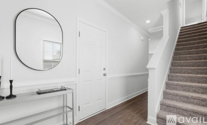 A staircase with a carpeted runner and a wooden handrail.