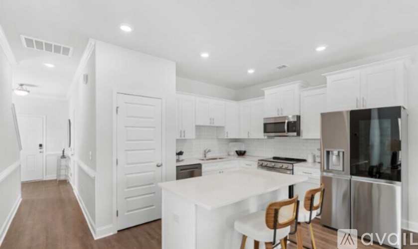 A modern kitchen with white cabinets and stainless steel appliances.