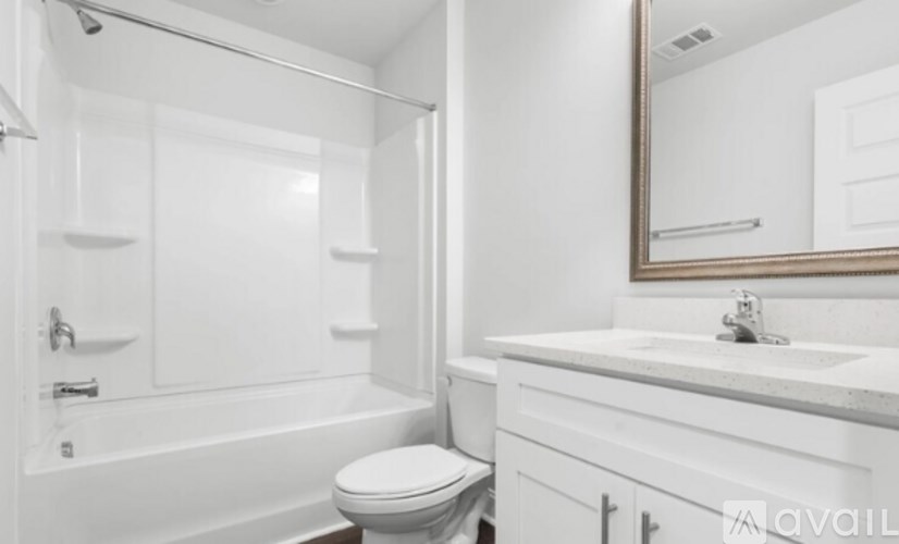 A white bathroom with a toilet, sink, and bathtub.