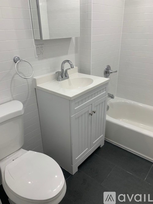 A white bathroom with a toilet, sink, and tub.