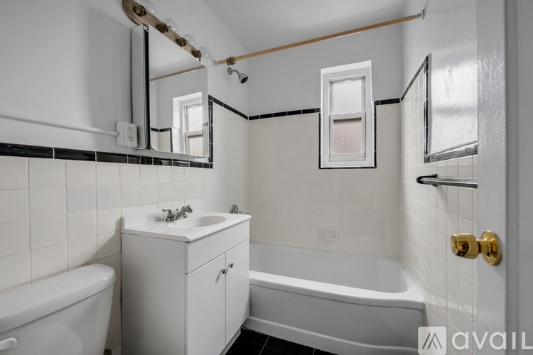 A bathroom with a white tub, sink, and mirror.