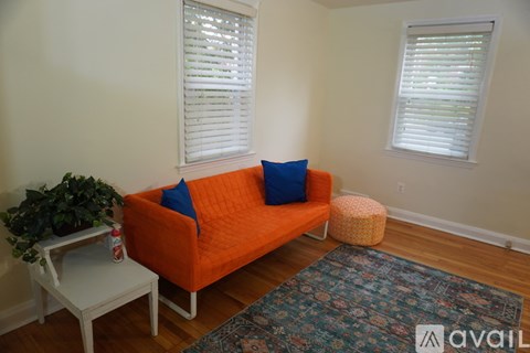 A living room with an orange couch and a white table.