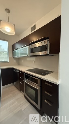 A kitchen with dark brown cabinets and stainless steel appliances.