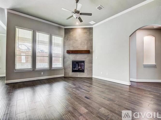 A spacious room with a fireplace and a ceiling fan.