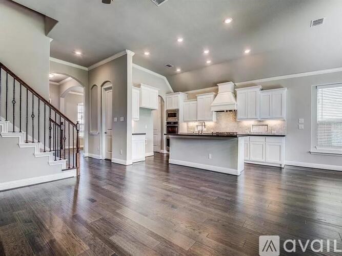 A spacious kitchen with a staircase on the left side.