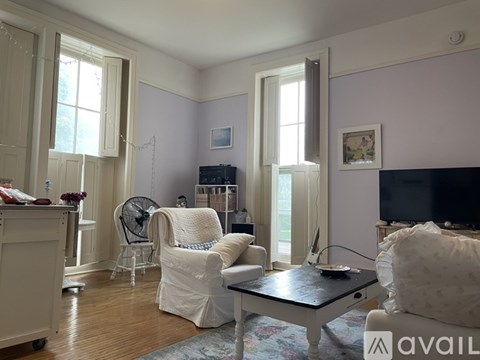 A living room with a white chair and a black table.