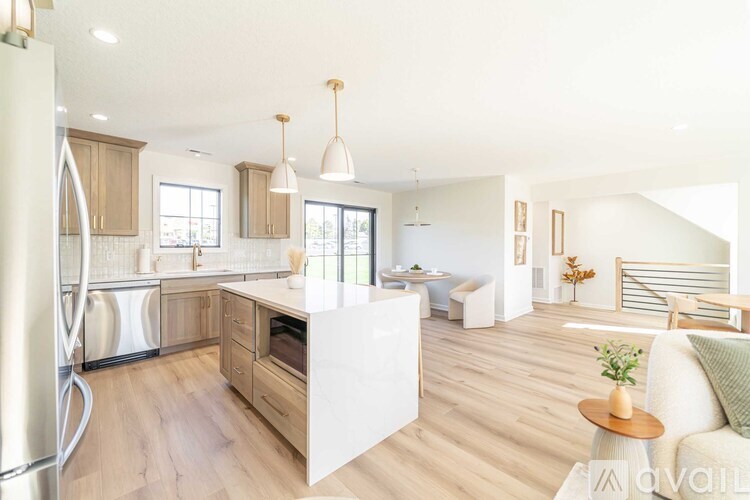 A modern kitchen with wooden floors and a large island.