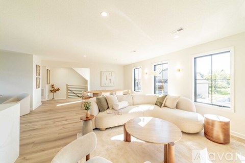 A living room with a white couch and a wooden coffee table.