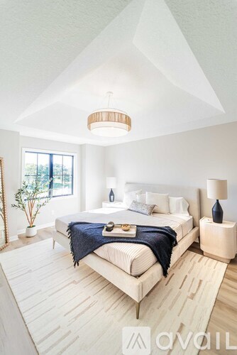 A bedroom with a large bed and a lamp on the side table.