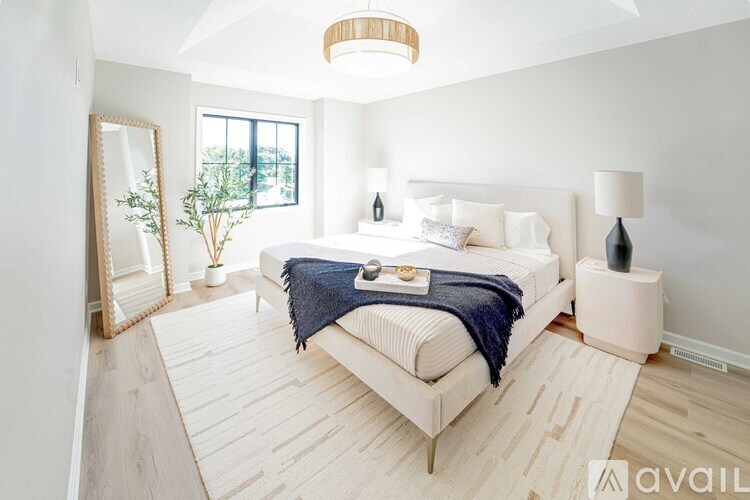 A bedroom with a large bed and a mirror on the wall.