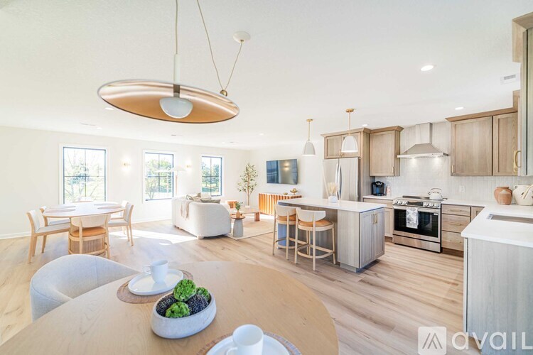 A modern kitchen with wooden chairs and cabinets.
