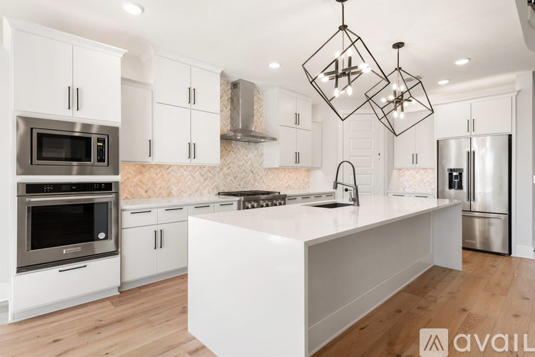 A modern kitchen with white cabinets and stainless steel appliances.