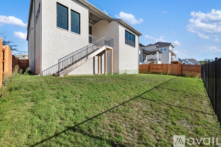 A house with a white exterior and a black fence is for sale.