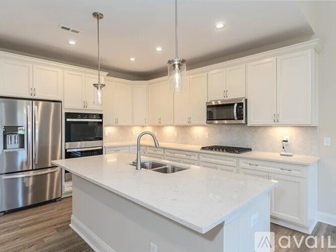 A modern kitchen with white cabinets and a central island.