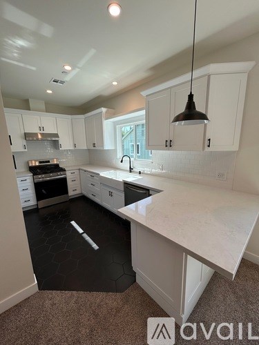 A kitchen with white cabinets and a large island.