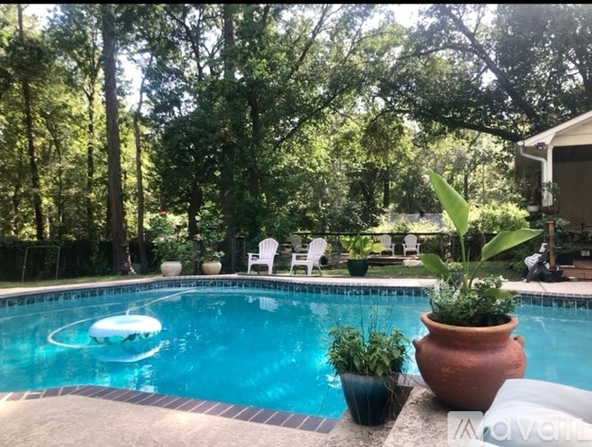 A pool with a blue tinted water and a white inflatable ring floating in it.