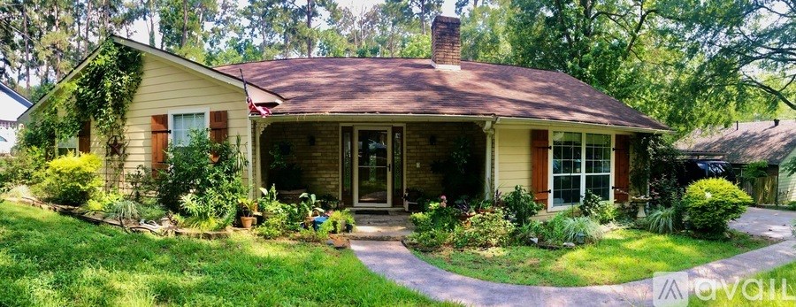 A house with a brown roof and a front porch with a door and two windows.