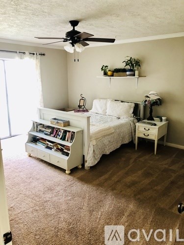 A bedroom with a bed, nightstand, and a bookcase.