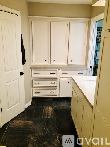 A kitchen with white cabinets and drawers.