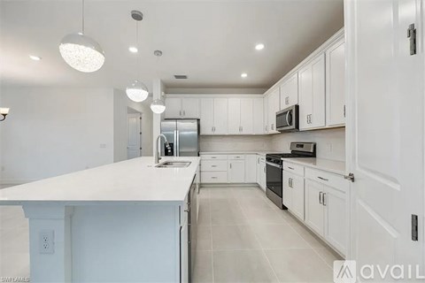 A modern kitchen with white cabinets and appliances.