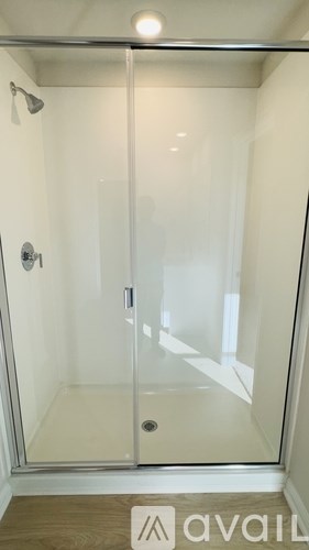 A glass shower stall with a door and a handle.