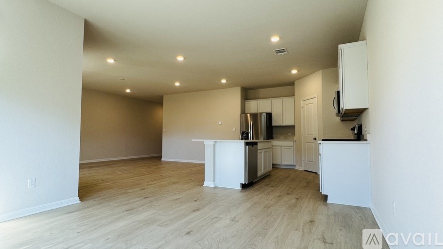 A kitchen with white cabinets and a wooden floor.